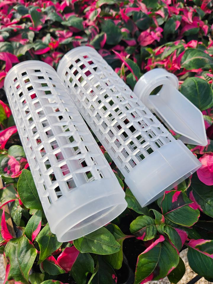 Clear fillable grow poles, 17 inches, reusable and stackable in garden with pink flowers.